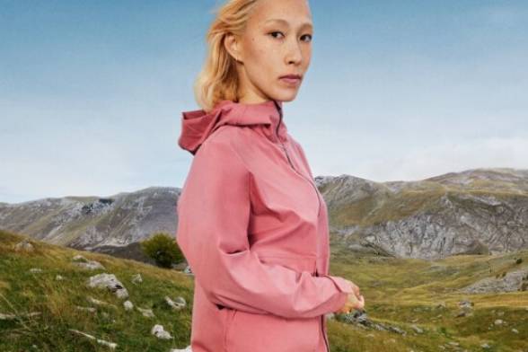 Young woman in sporty hiking clothes in a summery mountain landscape